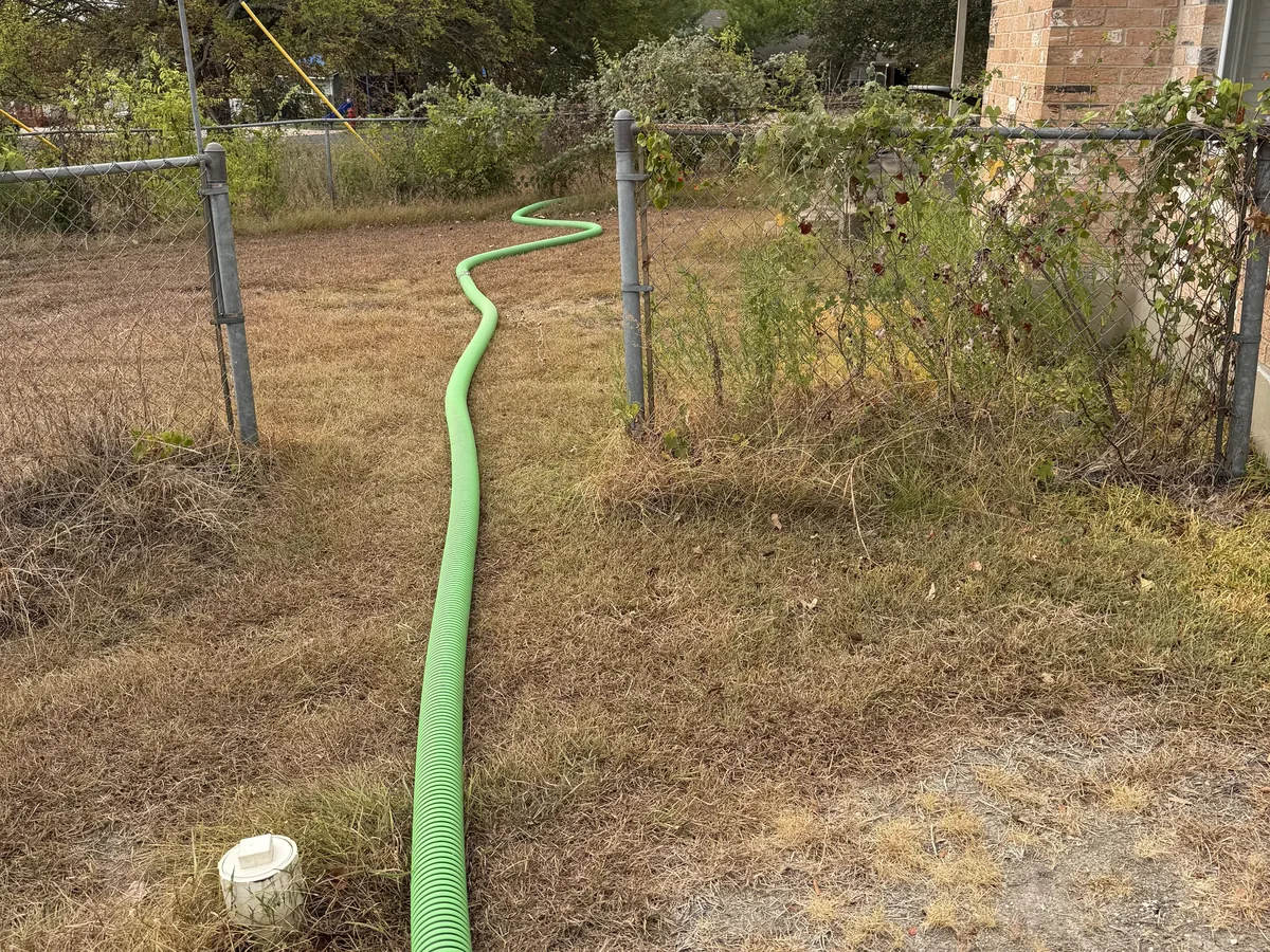 The suction hose run along a fence line to a septic tank at a home in Central Texas