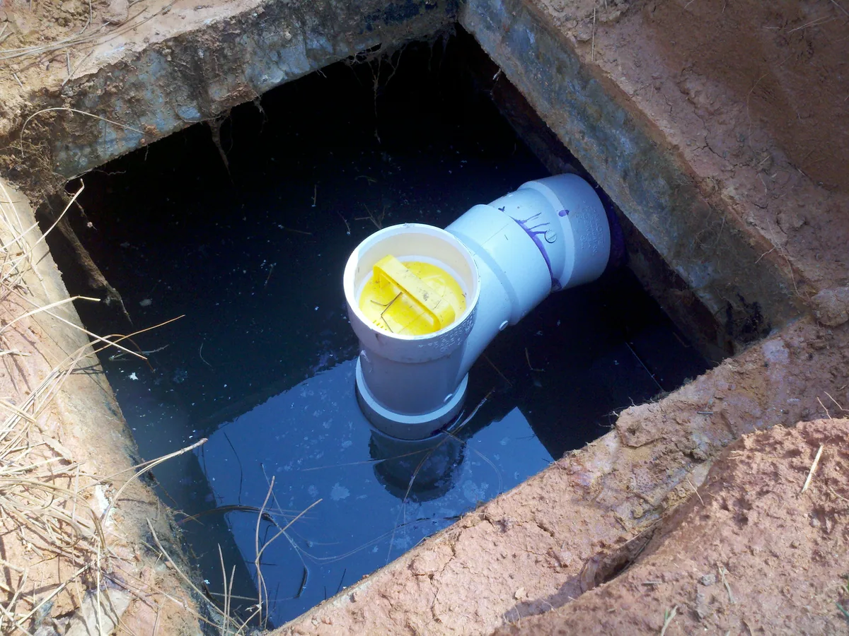 An effluent filter in the outlet tee of an opened septic tank